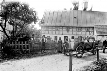 č. p. 27 - Starší žena uprostřed snímku je majitelka domu Josefa Krätschmer. Vedle ní stojí její děti Otto a Berta. Muž za vozem je Franz Löbel z č.p. 31