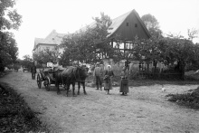 č. p. 34 - Muž s bičem se jmenuje (jméno neuvedeno) Teufel. Na voze sedí Josef Wolf a Rudolf Wolf. Za vozem stojí majitel domu Franz Wolf, jeho dcera Marie a manželka Hedwiga Wolf.